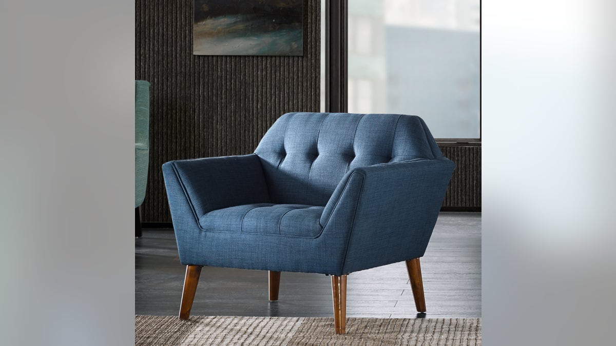 A blue Mercury Row Petrin tufted armchair in a living room