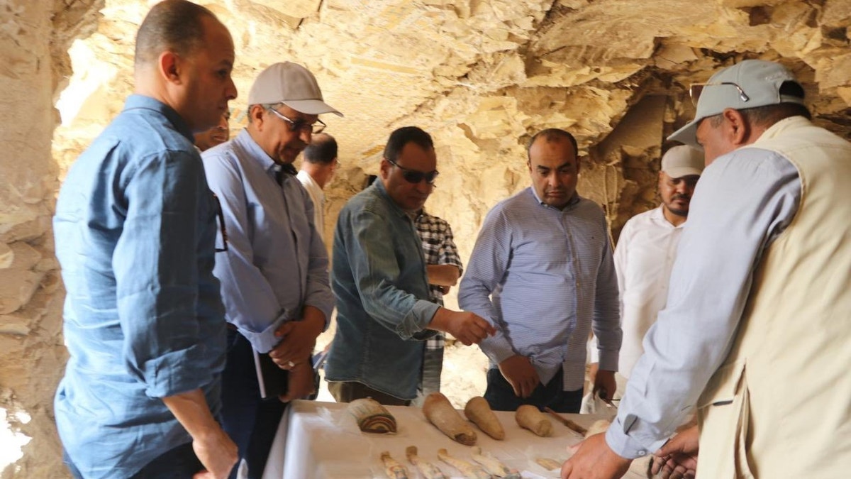 Officials standing in ancient tomb