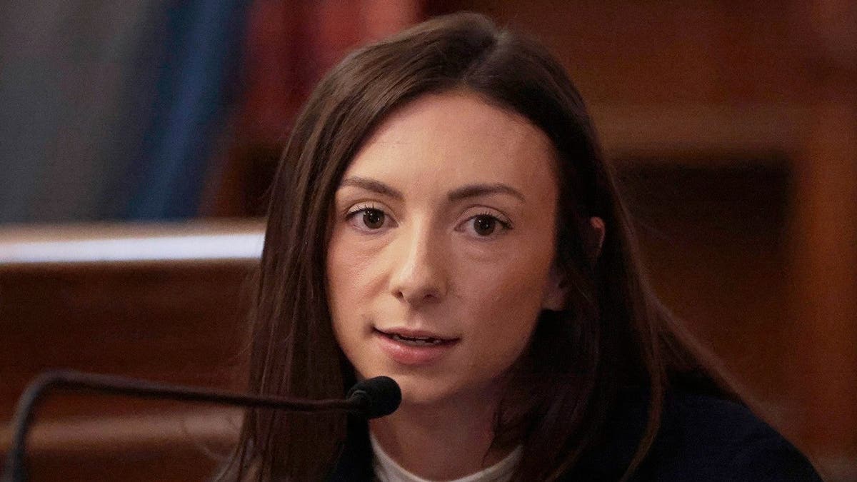 凯蒂·麦克劳林(Katie McLeulin)穿着一件深夹克,一件白衬衫和金项链。