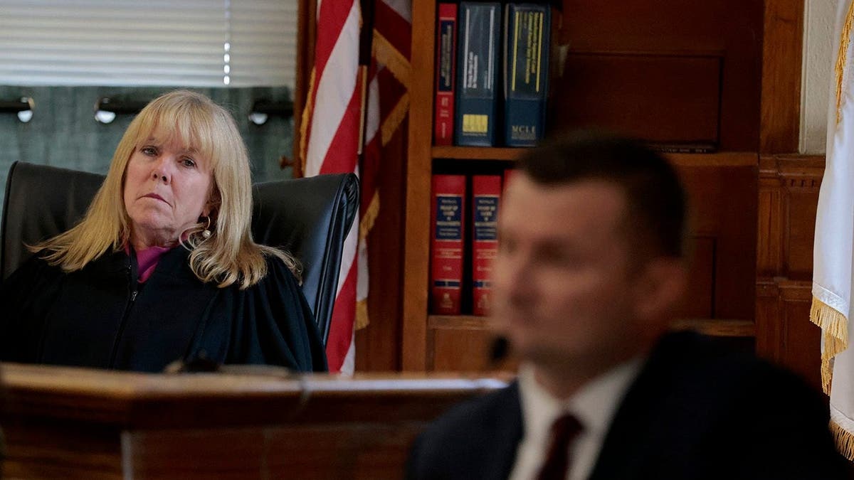 Judge Beverly J. Cannone leans to her near arsenic Sgt Yuri Bukhenik testifies