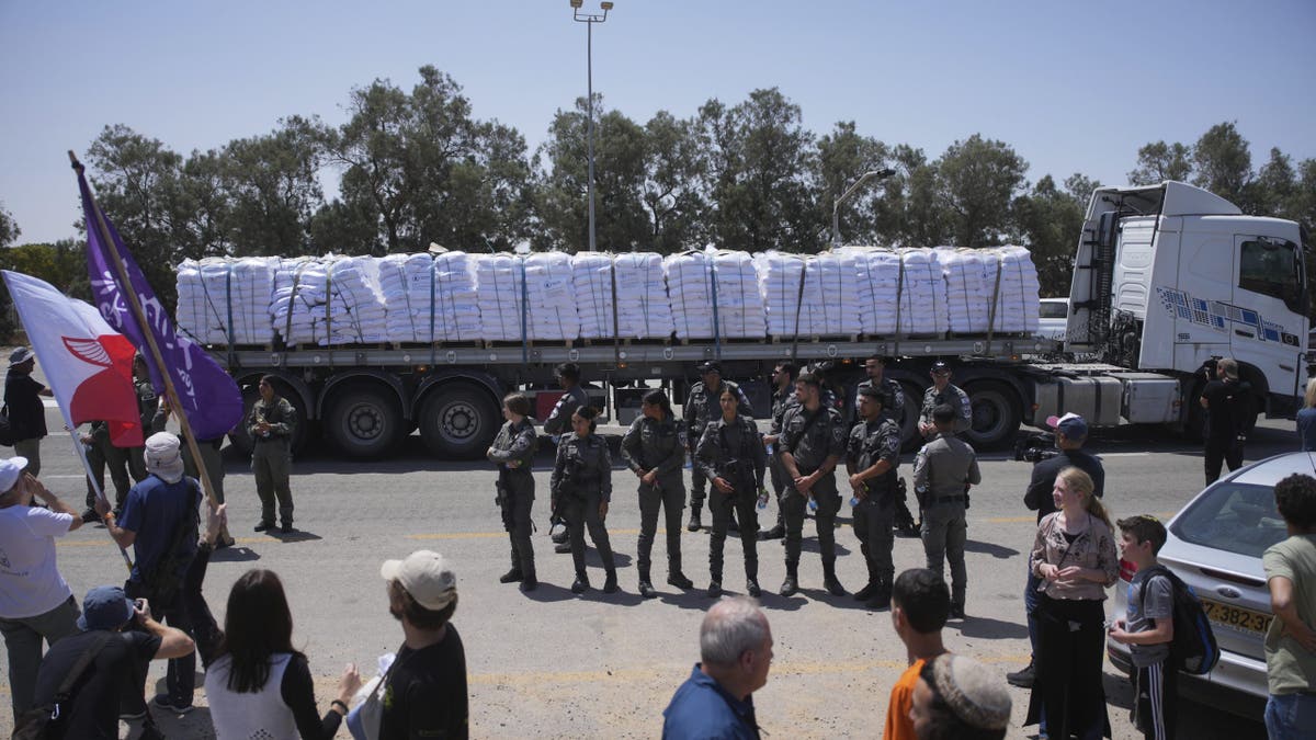 Soldiers stand in front of a humanitarian aid truck