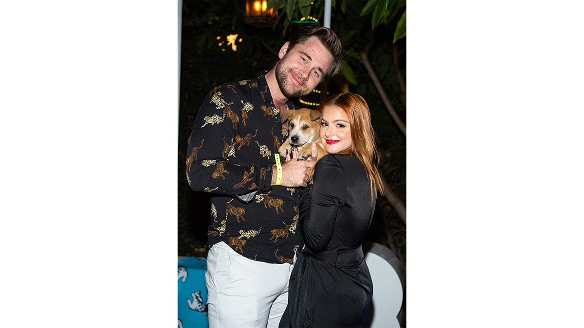Ariel Winters and her boyfriend Luke Benward hold a dog in a photo