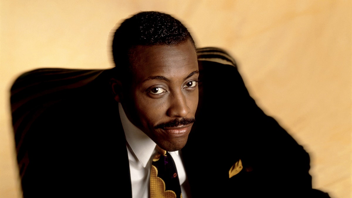 American comedian and talk show host Arsenio Hall poses for a portrait sitting in his chair in Los Angeles, California, circa 1991.