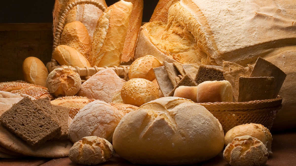 Table dressed up pinch various artisan breads produced pinch workplace light.