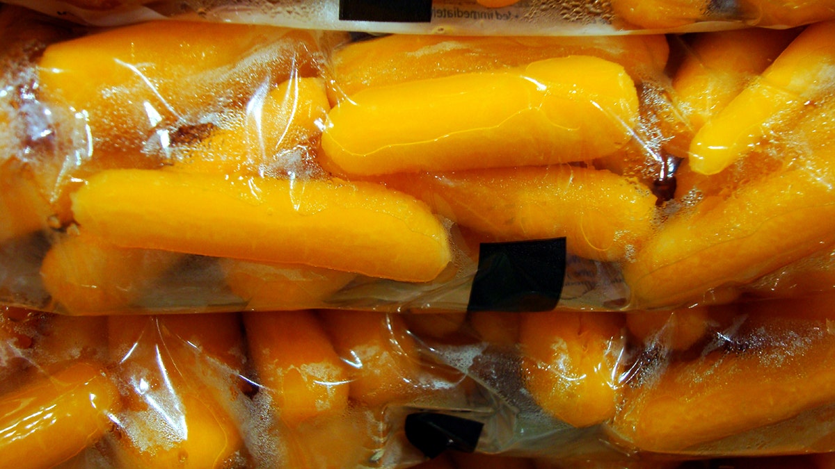 Baby carrots are bunched together in bags.