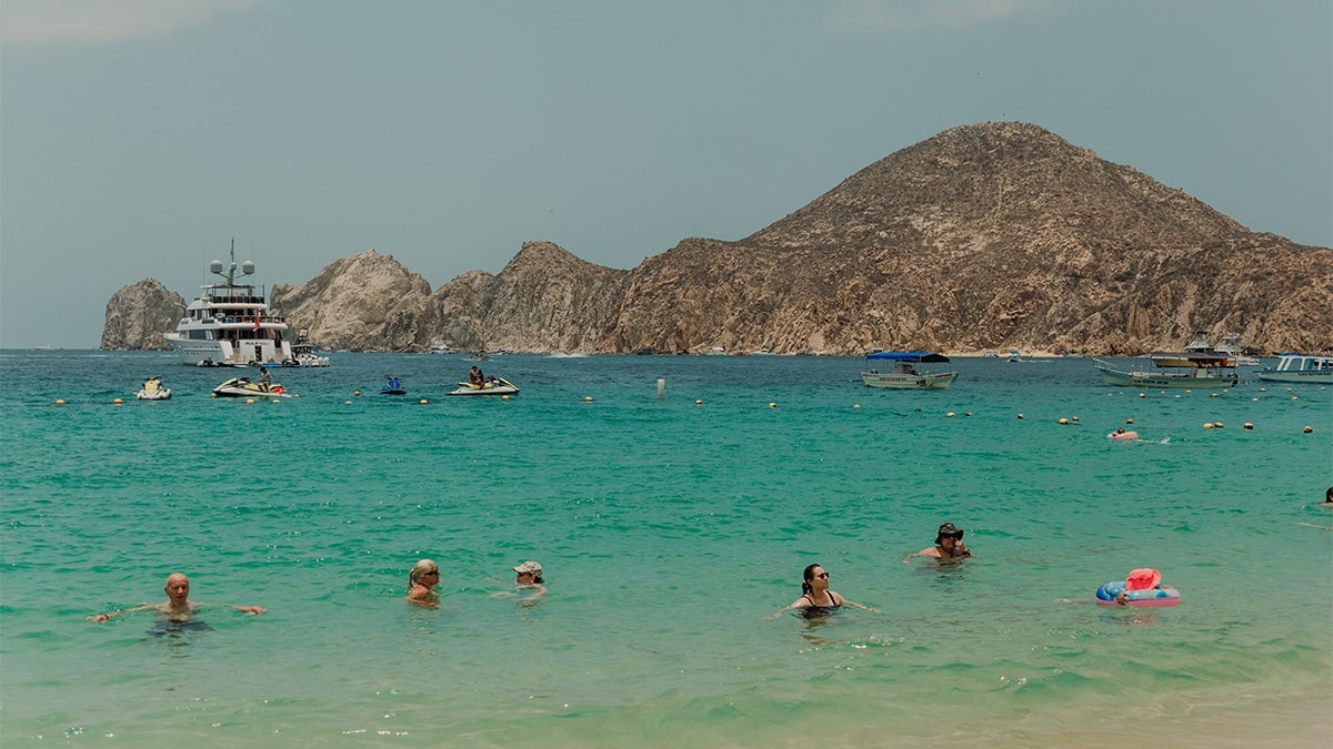 Tourists swimming at a beach in Cabo San Lucas in Mexico