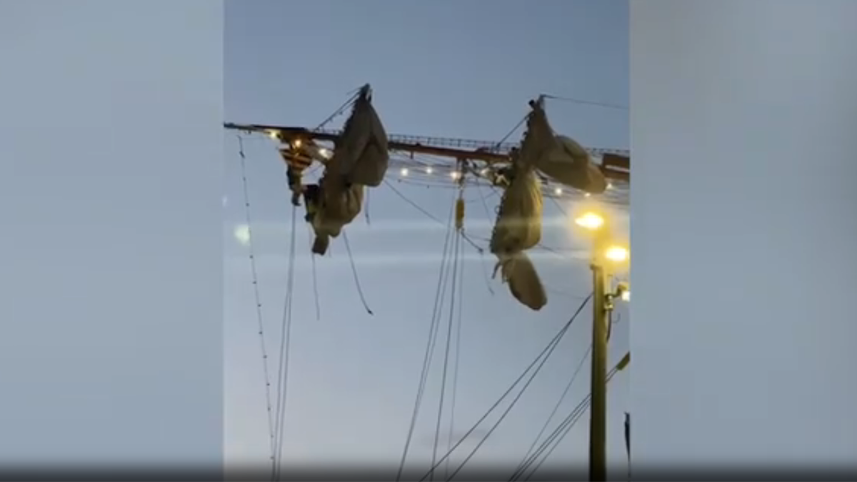 Mexican sailors dangling from rigging
