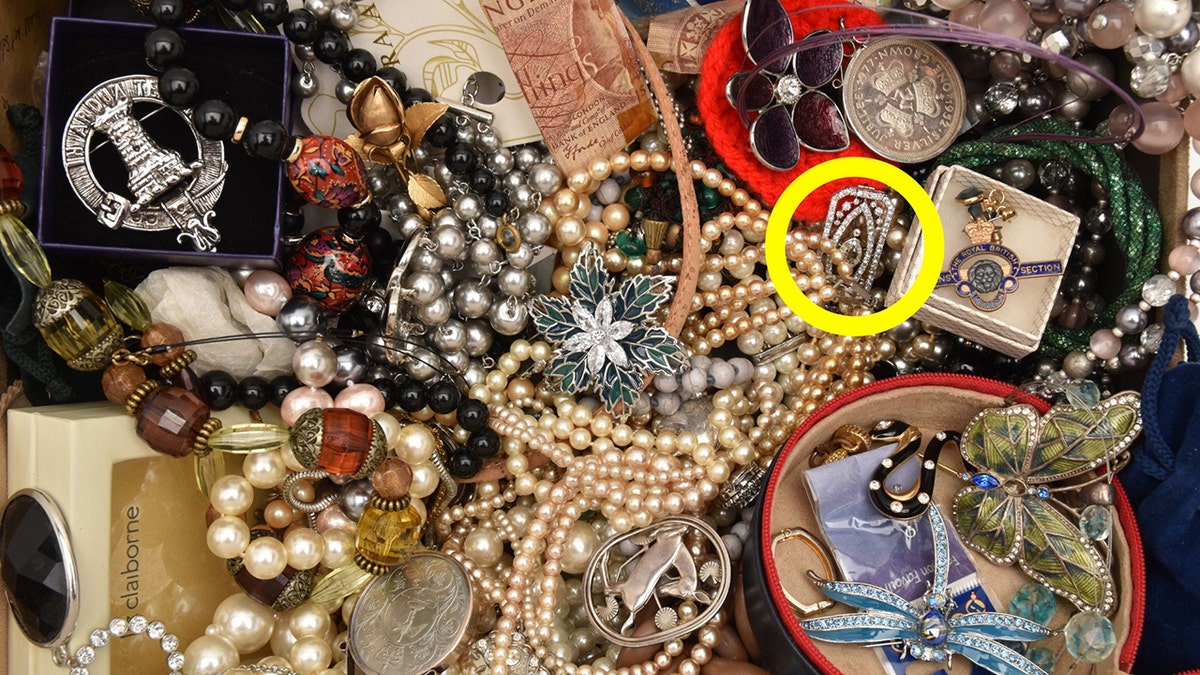 Art Deco brooch valued at £2.5K found hidden among costume jewellery. Release date May 26 2025. Can you spot the hidden treasure worth thousands among this box of old costume jewellery? An eagle-eyed auctioneer discovered a diamond brooch hiding in plain sight inside the innocuous box of jewellery which was brought along to a routine valuation day. The majority of items equated to being worth little more than £200 but the brooch turned out to be an Art Deco treasure, which later sold at auction for £2,300. It was spotted by Lisa Spence, head of jewellery at Richard Winterton Auctioneers, in Lichfield, Staffs., as she sifted through the collection. Lisa said: