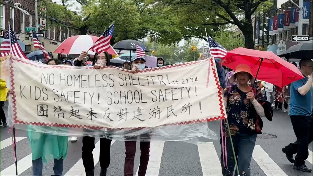 New Yorkers protest while holding massive banner