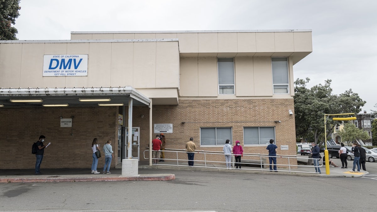 People wearing protective masks wait in line at the Department of Motor Vehicles (DMV) in San Francisco, California, U.S., on Monday, May 11, 2020. The first phase of eased lockdown measures went into effect on Friday allowing for stores to sell books, clothes, flowers and other items through curbside pickup. Photographer: David Paul Morris/Bloomberg