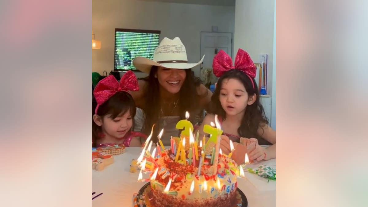 Cassie blowing out birthday candles with her daughter