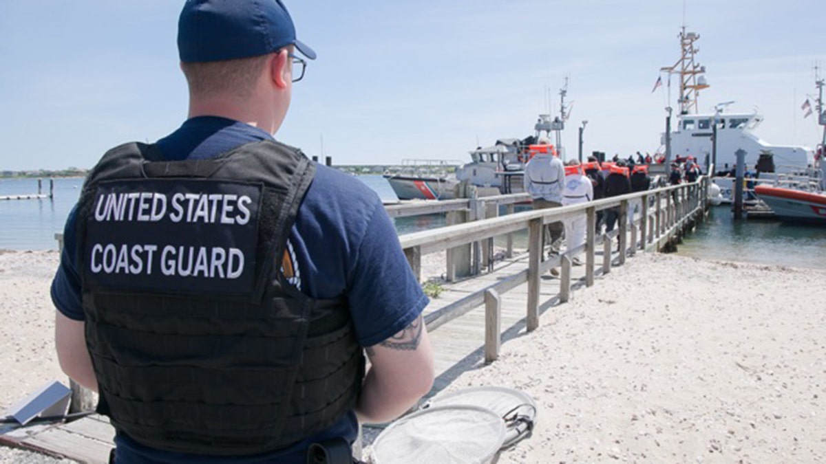 Man wearing vest that reads "UNITED STATES COAST GUARD"