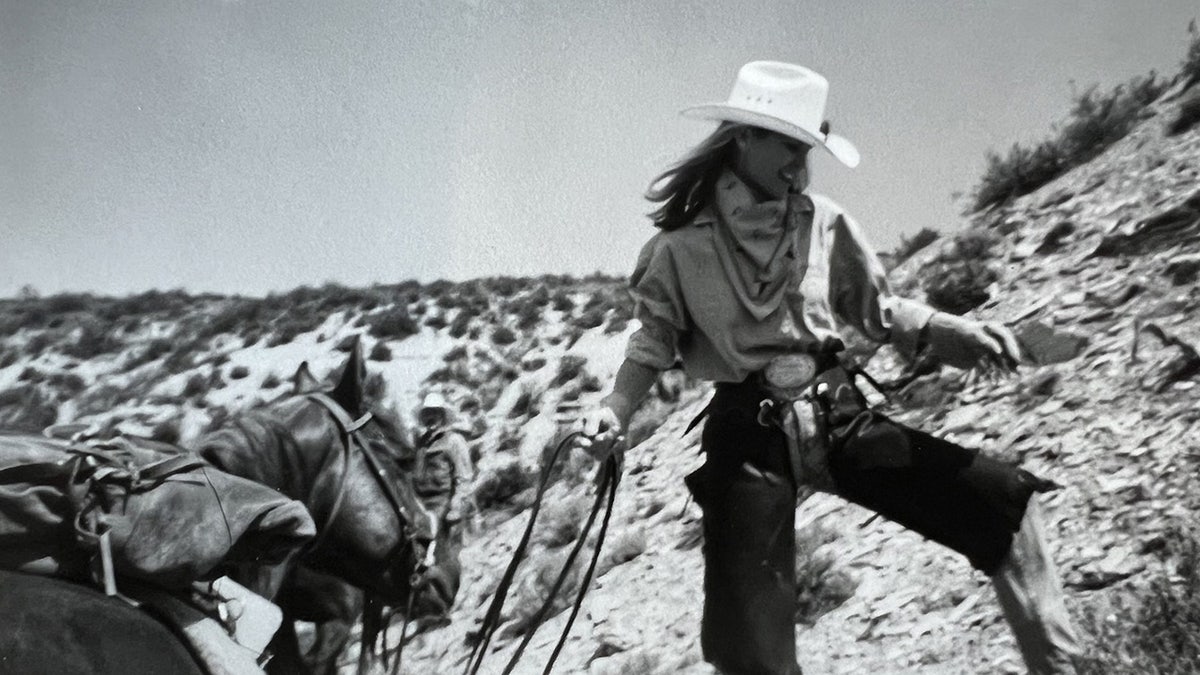 A black and white photo of Christie Brinkley on a mountaintop.