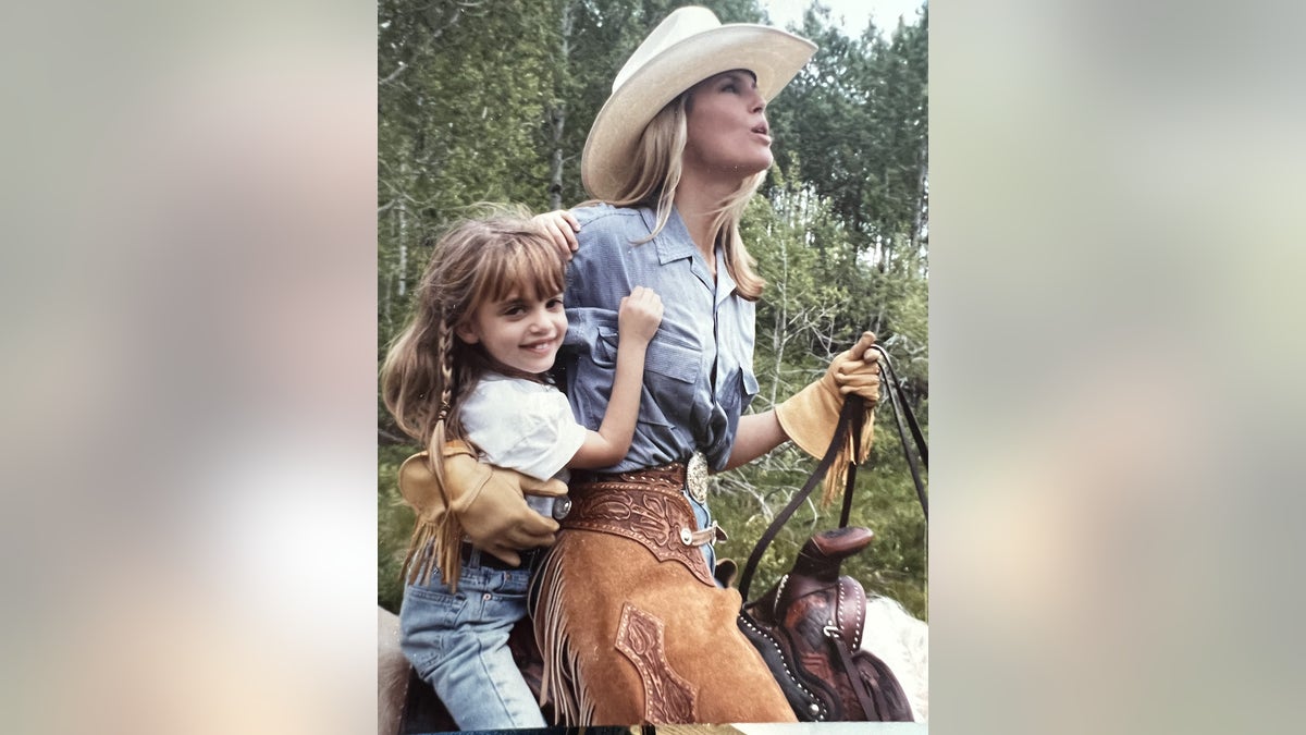 Christie Brinkley holding onto her daughter Alexa Ray on a horse.