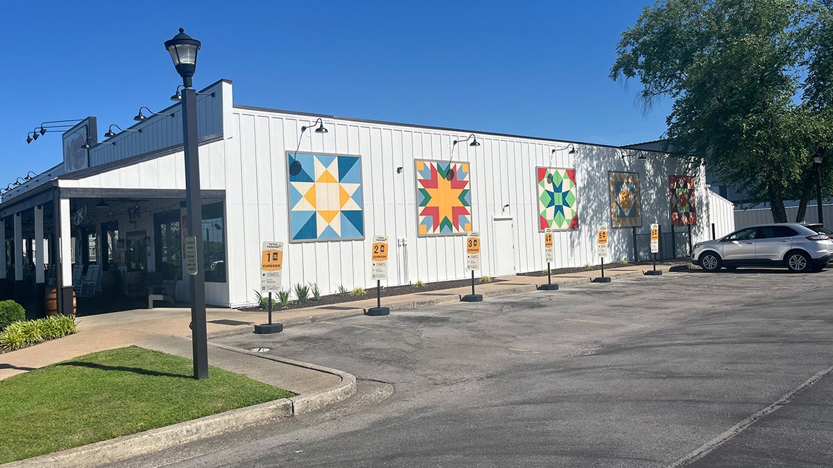 A Cracker Barrel with five murals on the side of one of its exterior white walls.