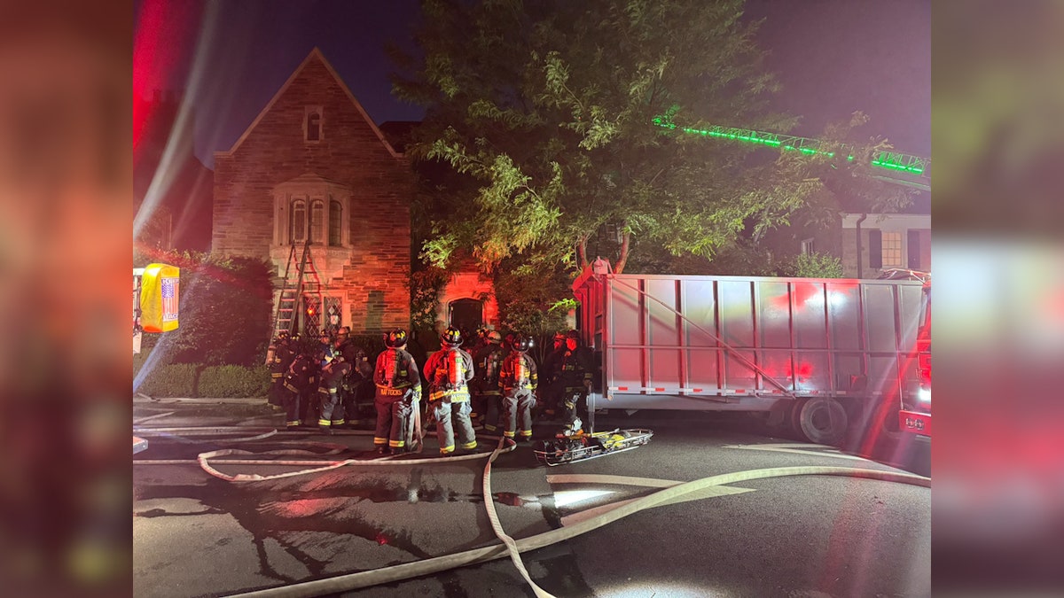 firefighters attend scene of house fire at night