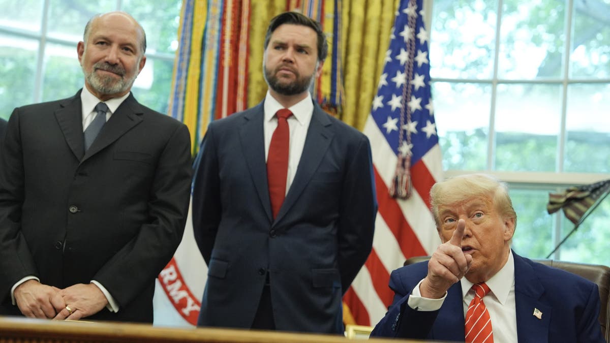 President Donald Trump, right, gestures and is joined by Vice President JD Vance, center, and Commerce Secretary Howard Lutnick, as he speaks with reporters after announcing a trade deal with the United Kingdom in the Oval Office of the White House on Thursday, May 8, 2025 in Washington, D.C.