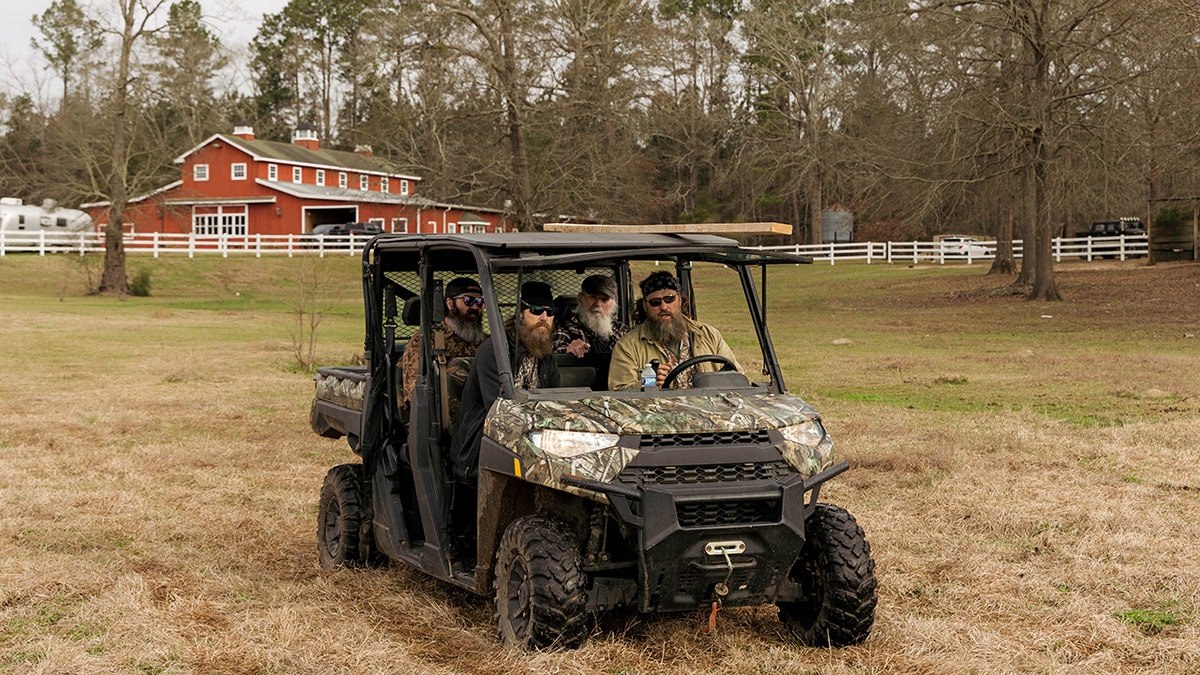 The cast of Duck Dynasty in a camouflage four wheeler.