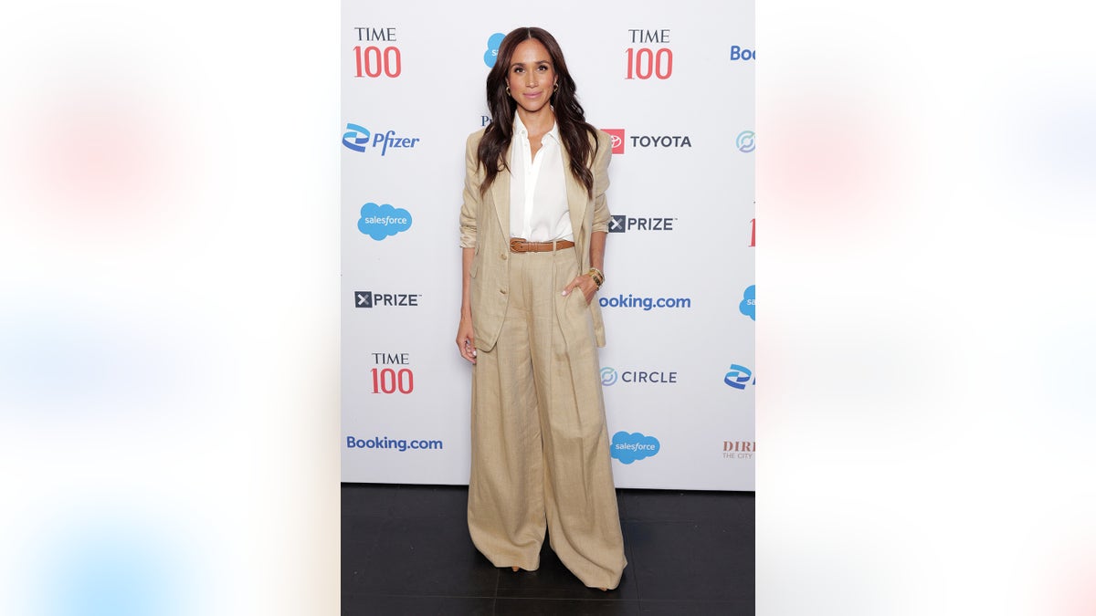 Meghan Markle wearing oversized beige pants and a matching blazer with a white blouse.