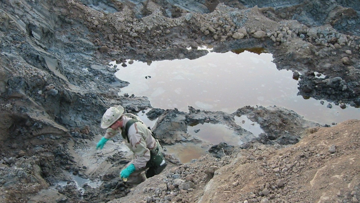 Researcher explores substances in excavation pit