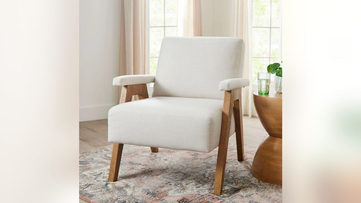 This chair is available in olive green or cream linen and will complement various home decor styles.