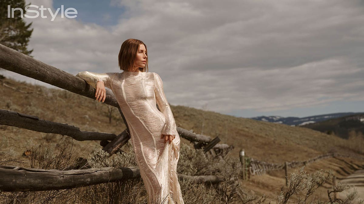 jessica biel leaning against a fence at her montana home