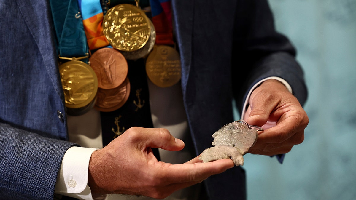 Gary Hall Jr. holds melted medal