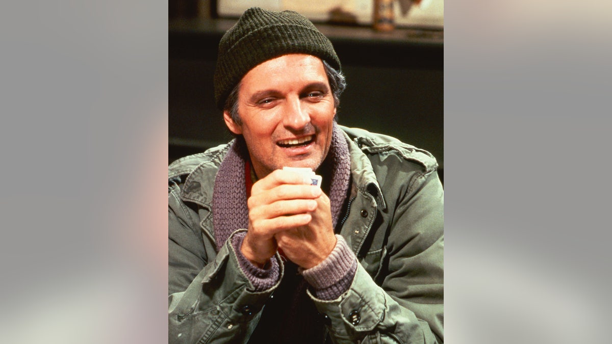 Alda alda with his arms folded in character as Hawkeye.