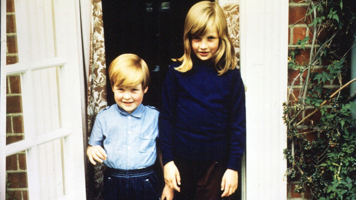 A young Princess Diana and Charles Spencer standing next to each other outside their home.