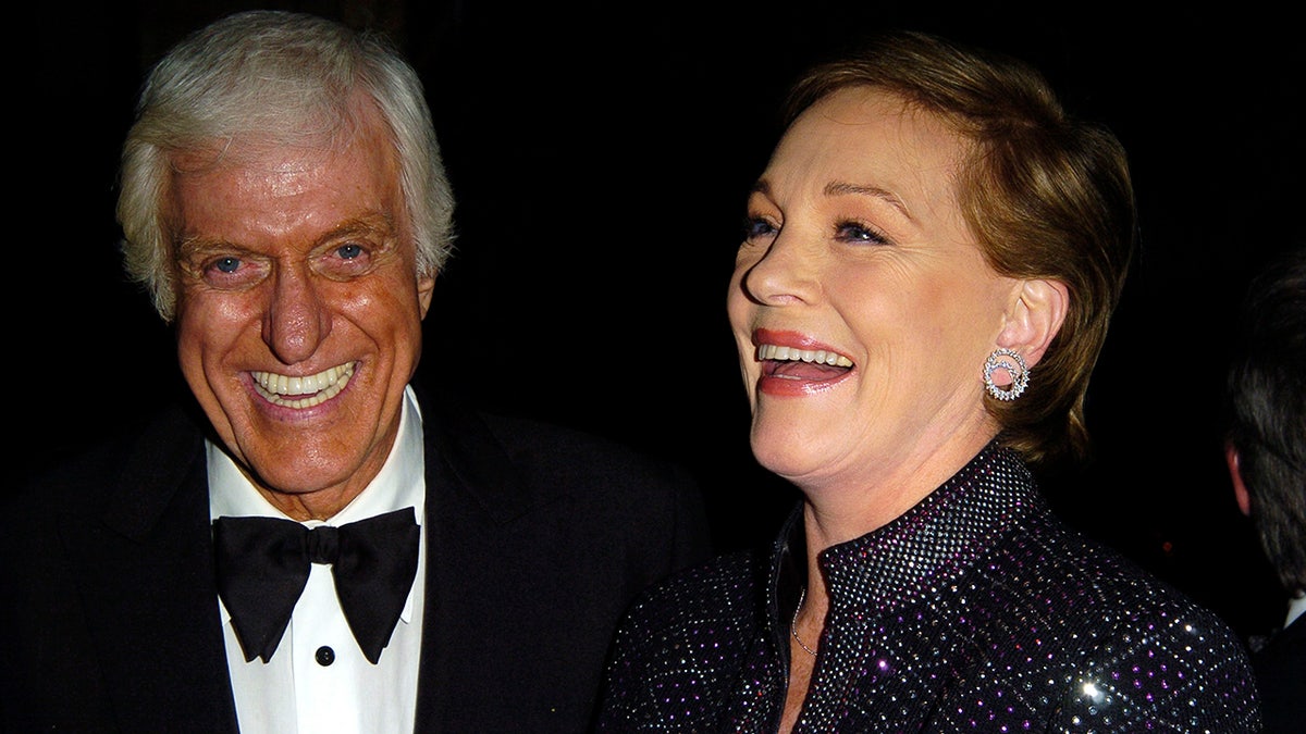 Dick Van Dyke and Julie Andrews standing near each other and sharing a laugh.