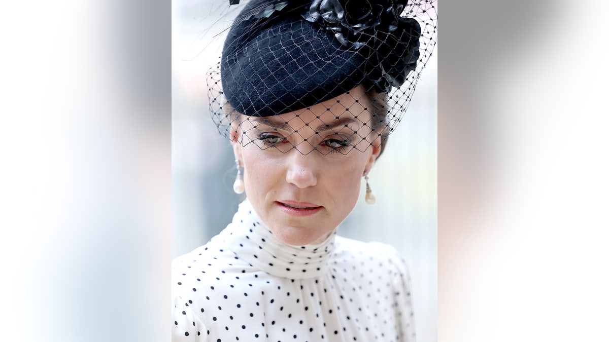 A close-up of Kate Middleton wearing a polka dot dress and a black fascinator.