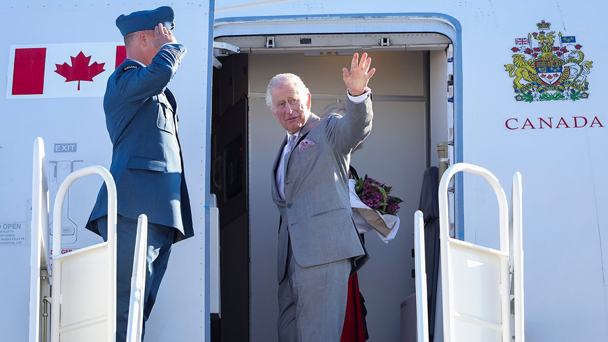 King Charles waving from a plane.