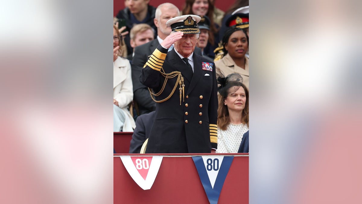 King Charles giving a salute in uniform.