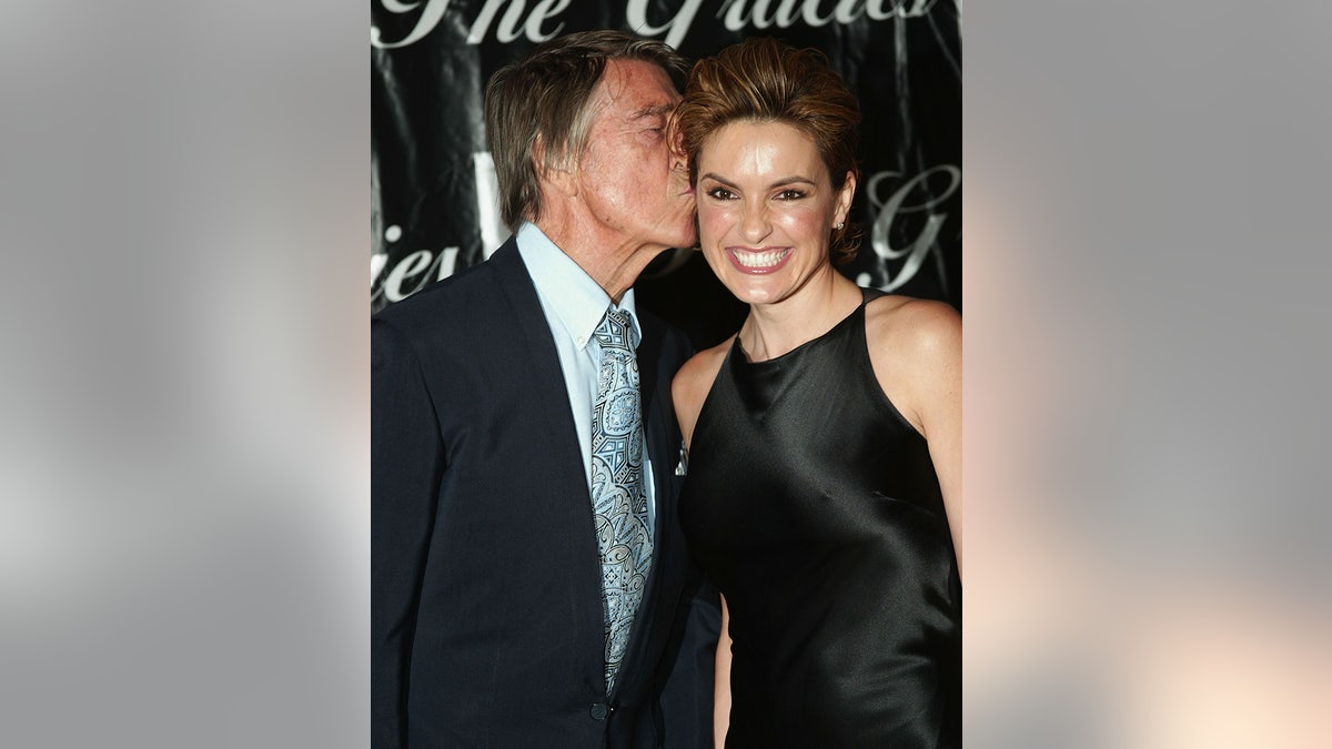 Mickey Hargitay kissing Mariska Hargitay on the temple.