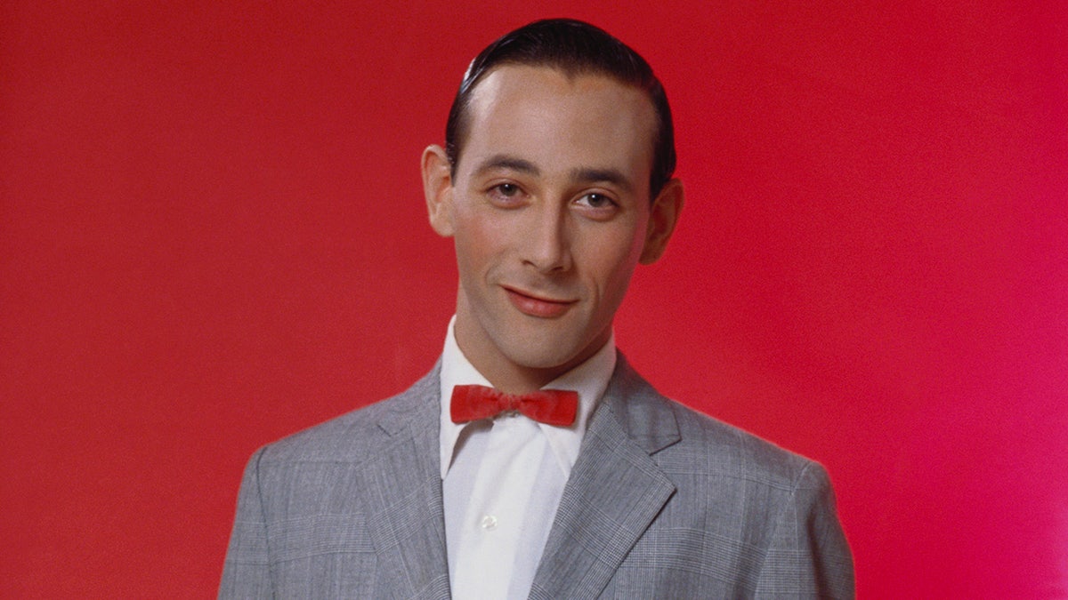 A close-up of Paul Reubens as Pee-wee Herman in his grey suit.