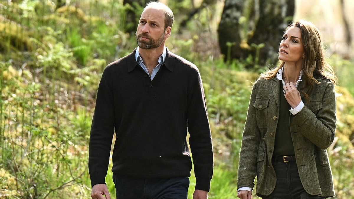 Prince William and Kate Middleton walking outdoors together in casual wear.