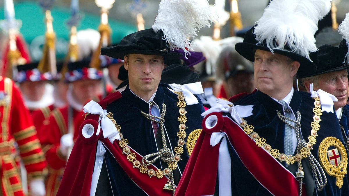 Prince William in royal robes walking behind his uncle Prince Andrew.