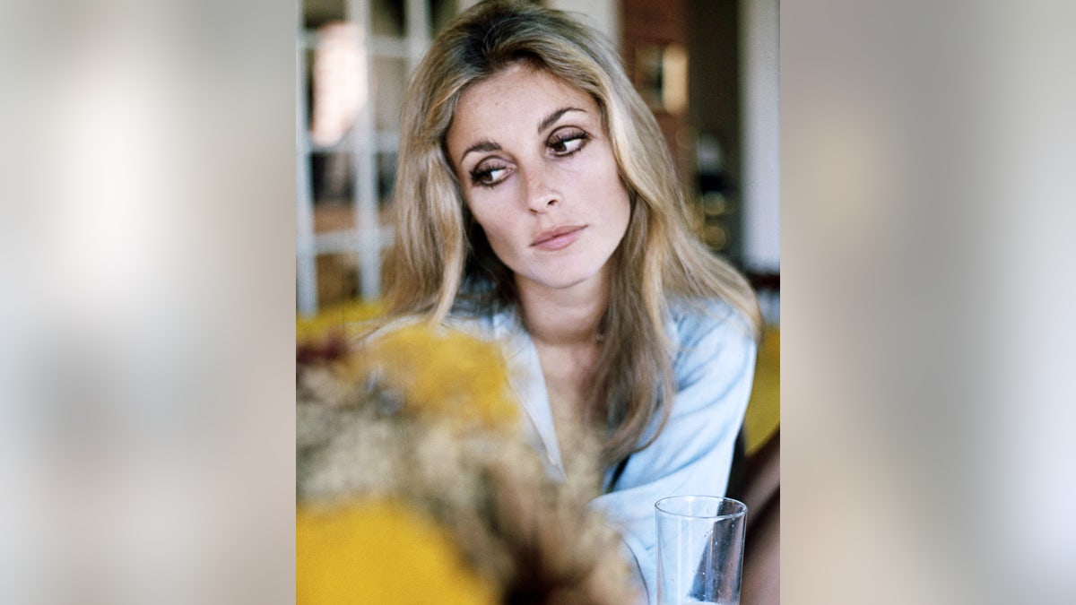 Sharon Tate wearing a light blue blouse and looking away.