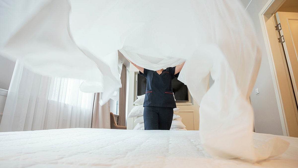 Maid doing the bed at hotel room