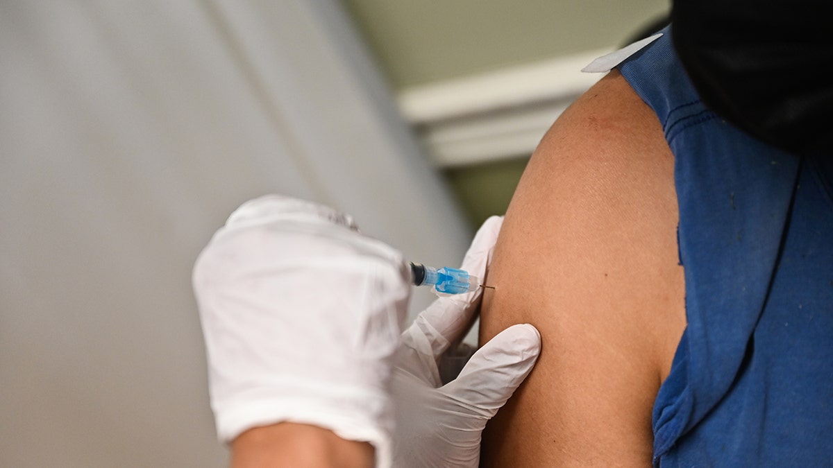 Closeup of man's arm receiving the Moderna COVID-19 vaccine