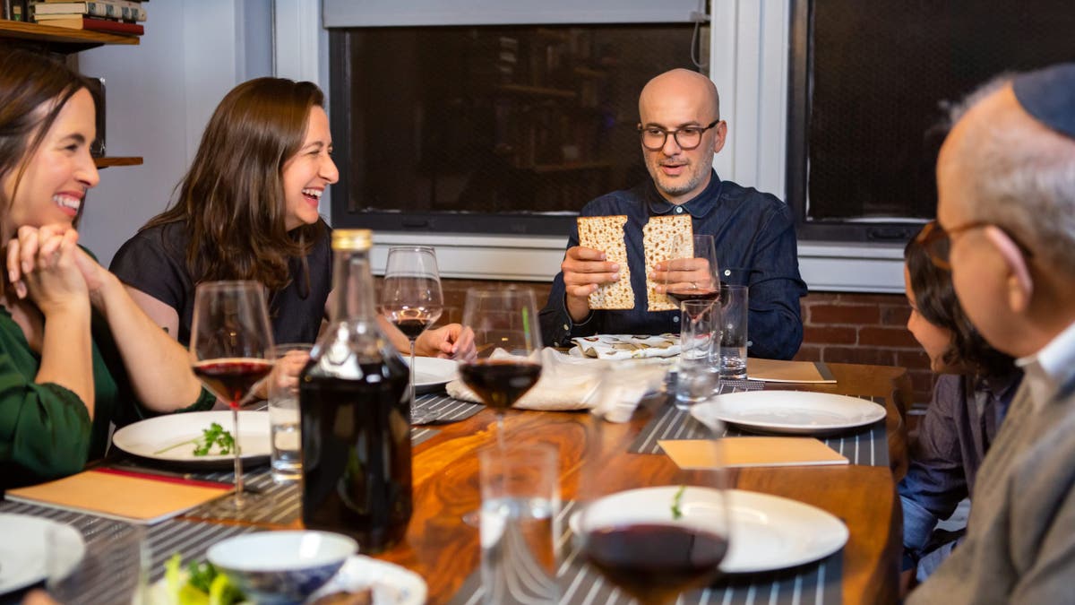 A modern Jewish American family celebrates Passover together. The Seder leader breaks the middle matzo (Yachatz).