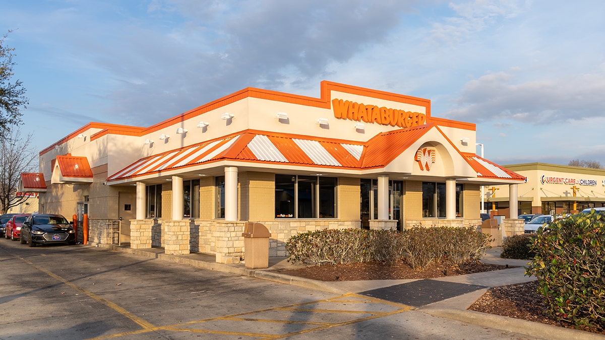 A Whataburger restaurant in New Orleans with an orange striped roof.
