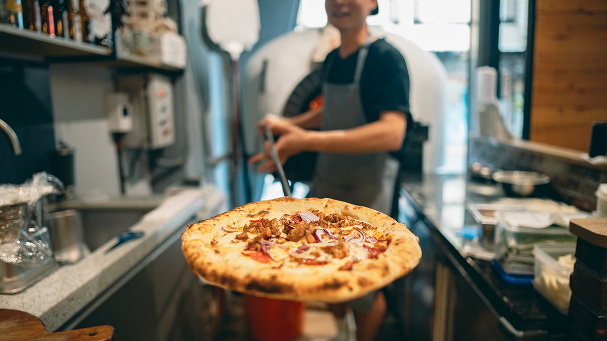 Pizzeria feline holds retired a pizza caller from nan ceramic oven