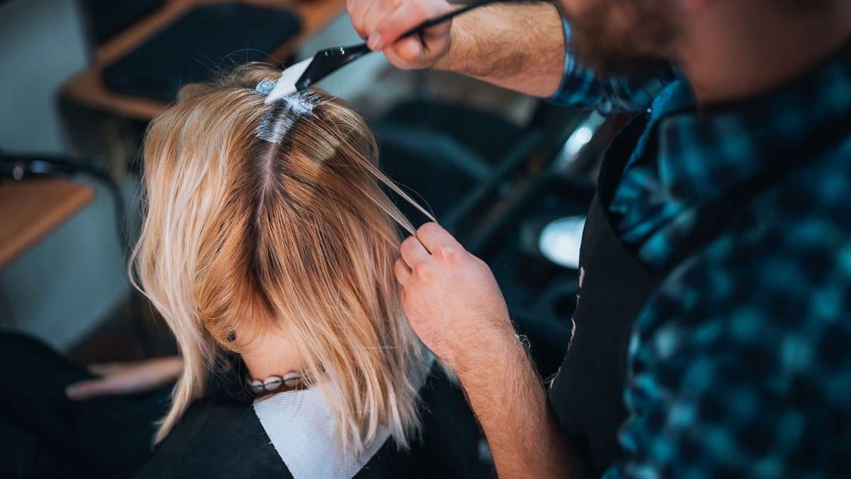 woman getting her hair dyed in a salon