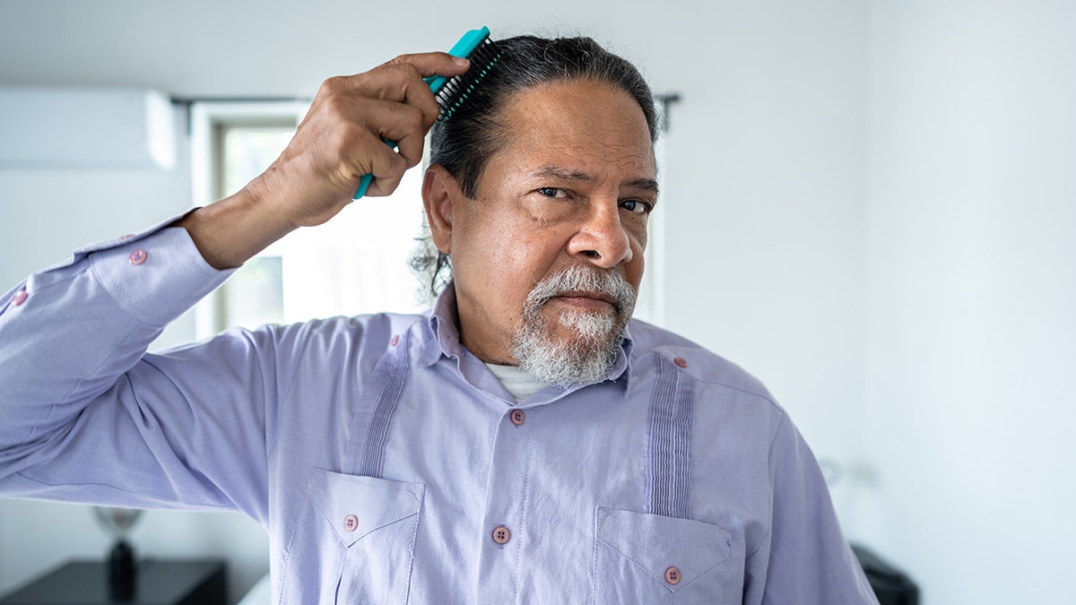 man combs hair