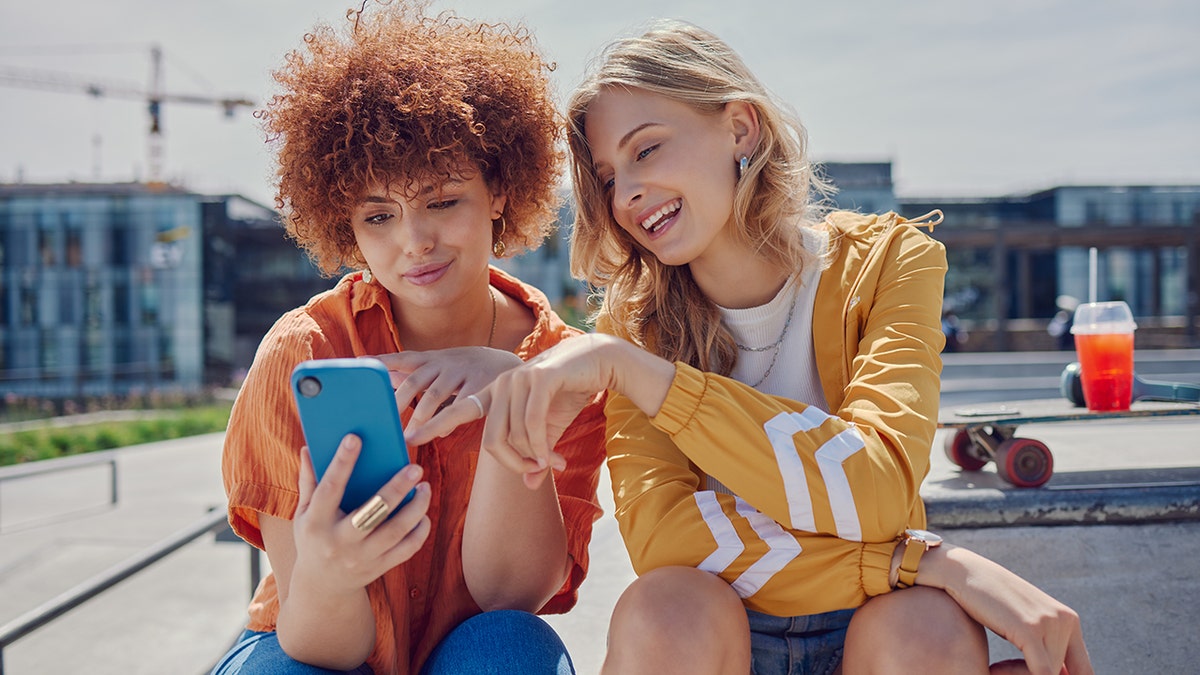 two friends looking at their phone