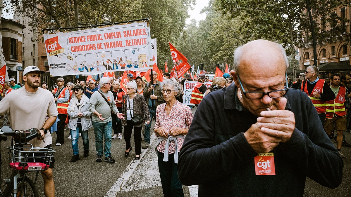 A French protester lights a cigarette