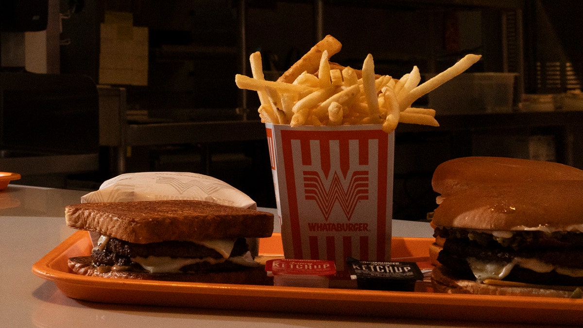 Sandwich fries and hamburger on an orange tray at whatabaurger.