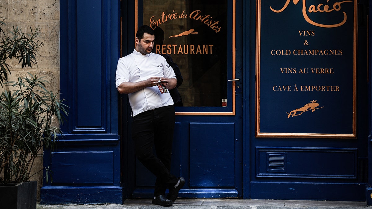 A chef rolls a cigarette in Paris