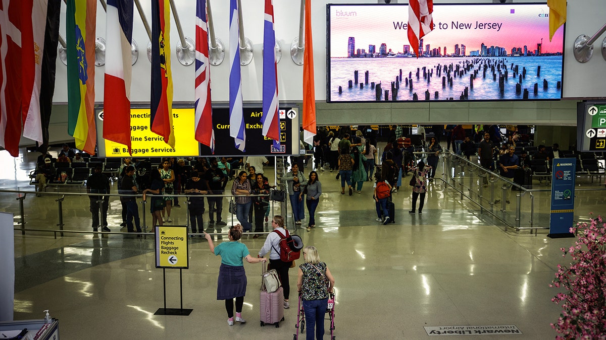 travelers walk through newark airport